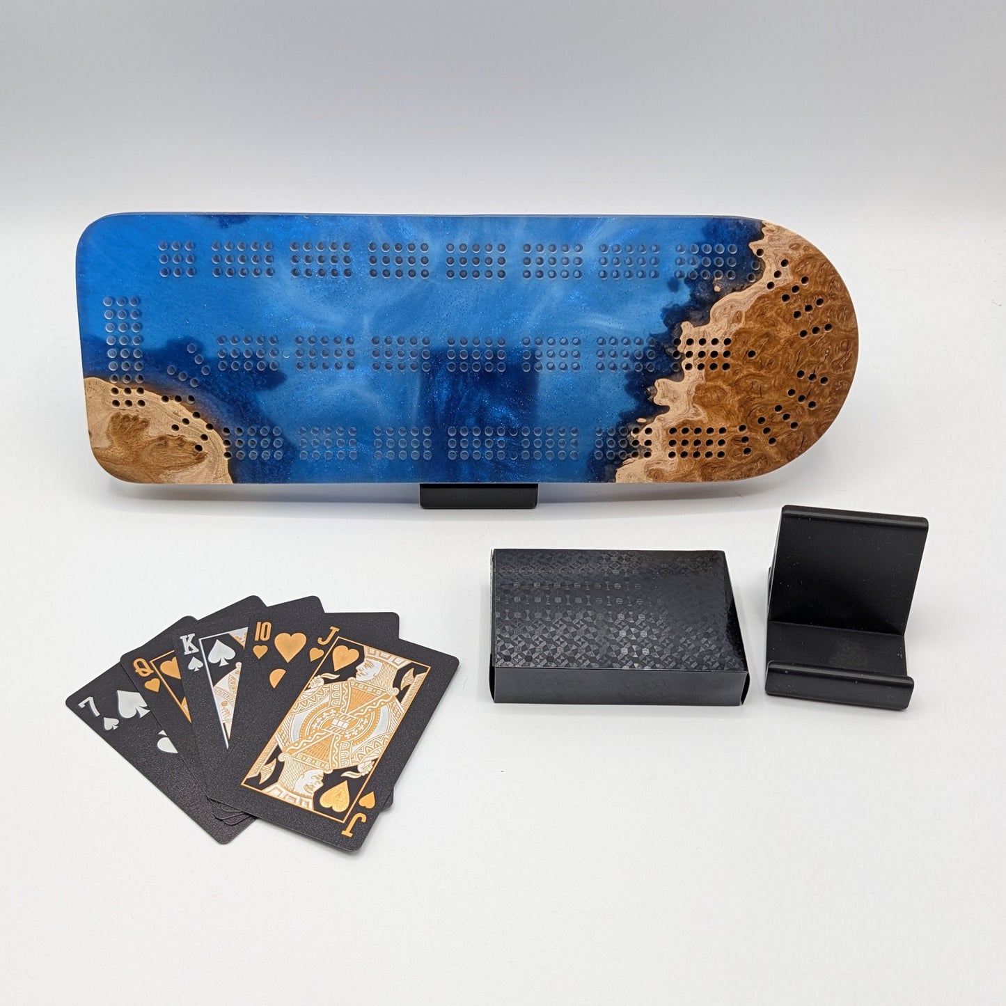 Cribbage board with cards and pegs on a white surface