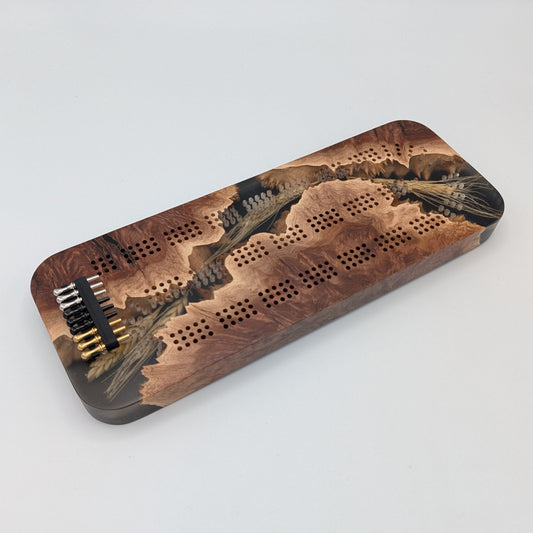 Wooden cribbage board with pegs on a white surface