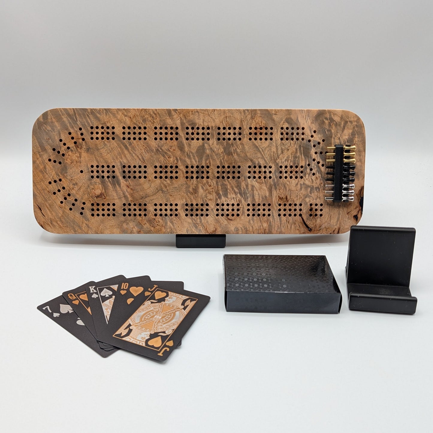 Wooden cribbage board with cards and dice on a white background