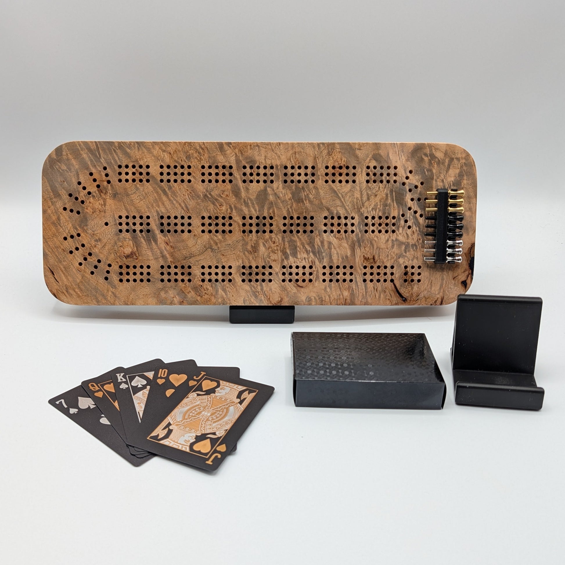 Wooden cribbage board with cards and dice on a white background