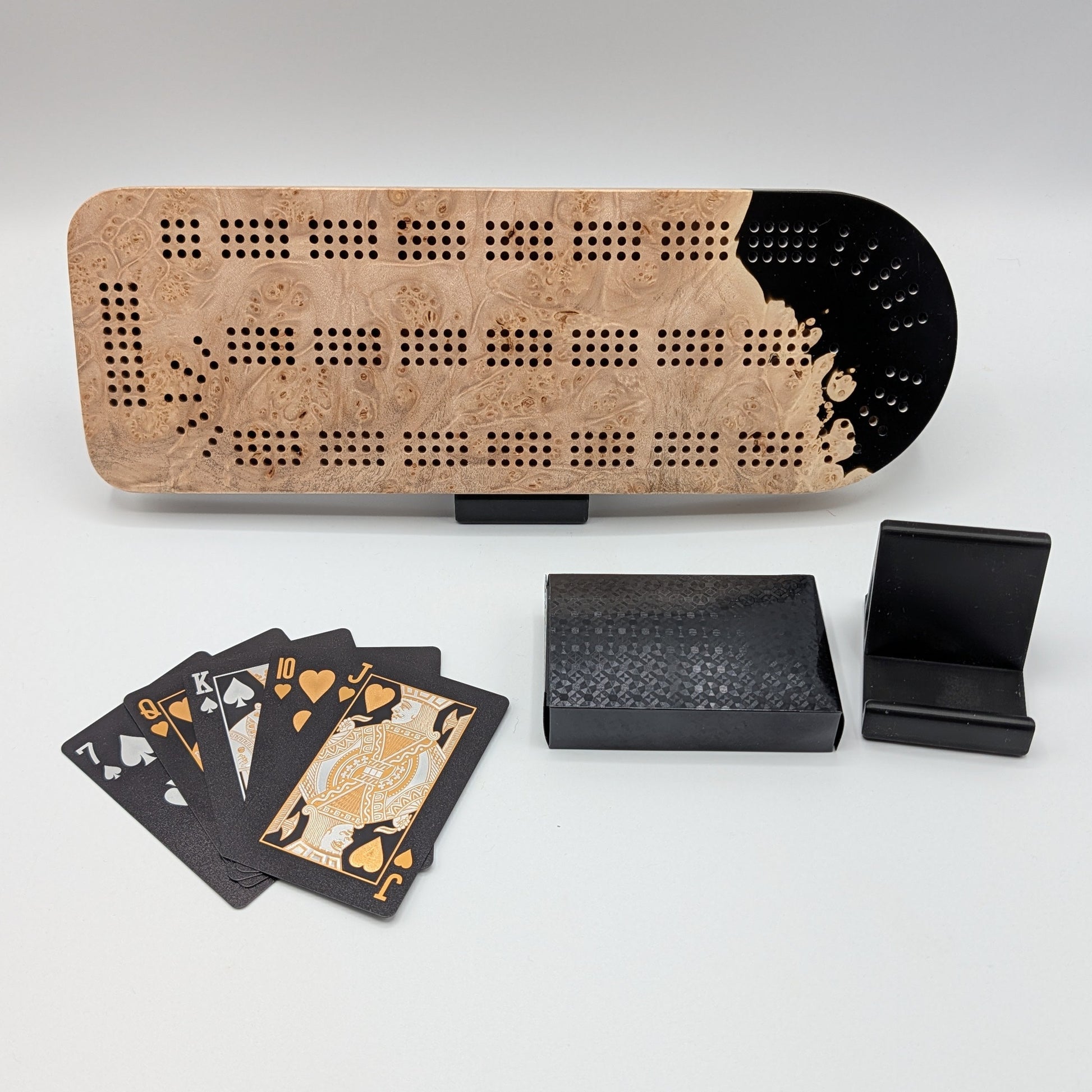 Cribbage board with cards and dice on a white surface