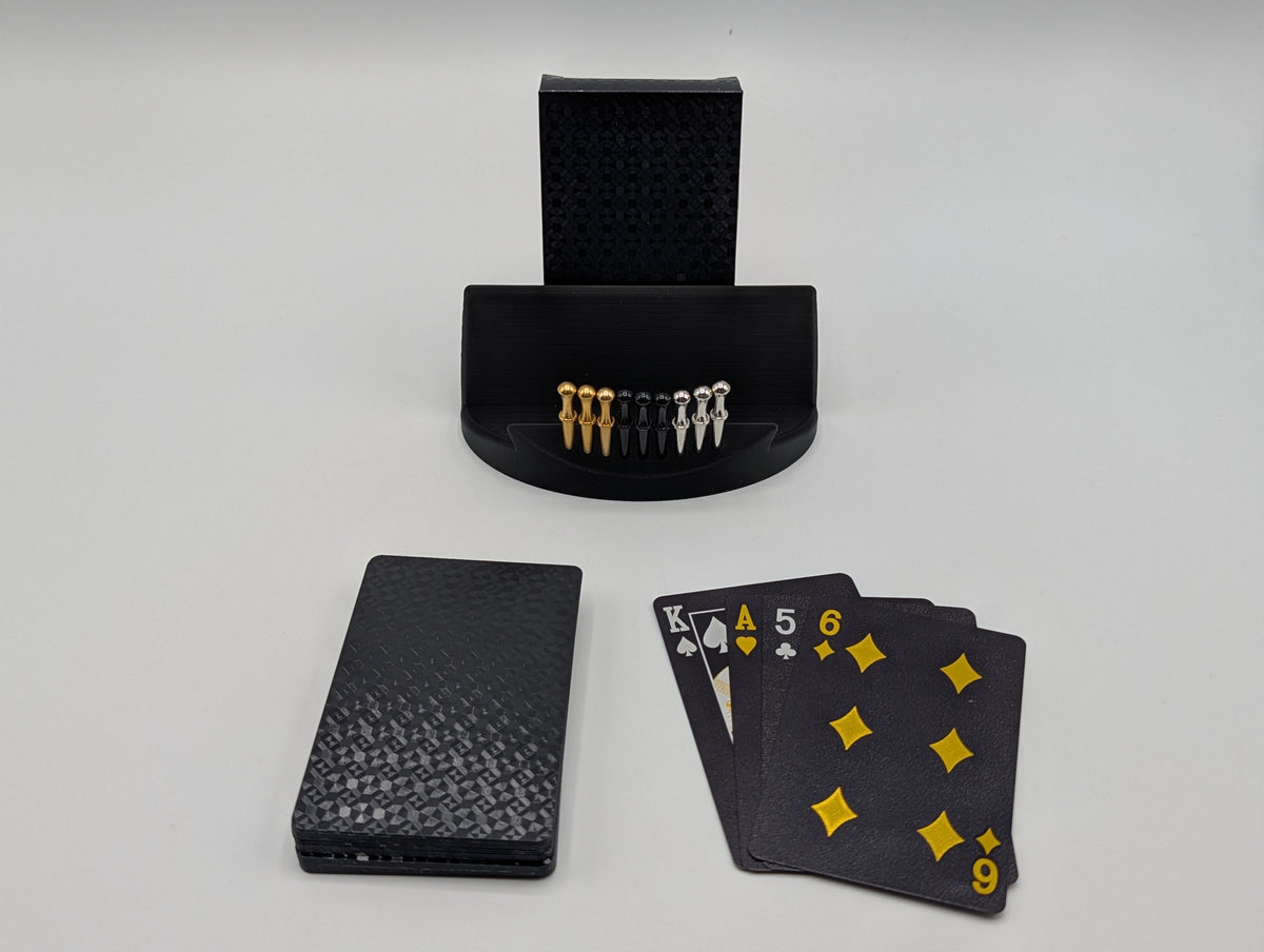 Black waterproof plastic playing cards shown with a Derevo cribbage stand and pegs; only the deck is included
