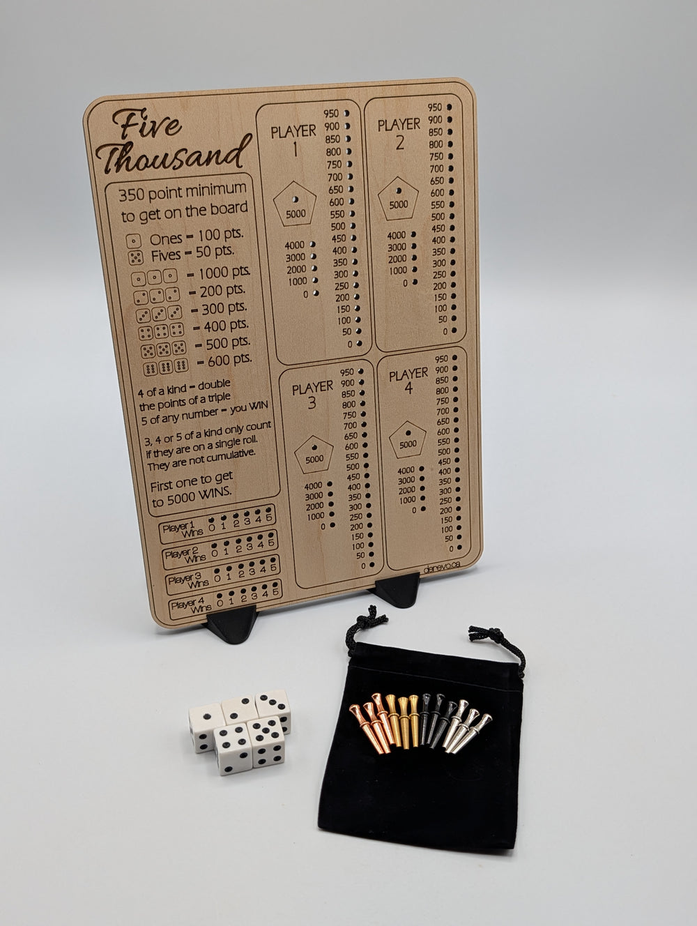 Five Thousand maple score board with four player tracks and an engraved scoring guide, shown with dice, metal pegs, pouch and two stands.