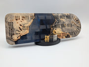 Origin cribbage board with buckeye burl wood and a central channel of deep blue galaxy epoxy.