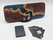 Origin cribbage board in Australian red mallee burl and midnight blue epoxy, shown on its stand with pegs and cards.