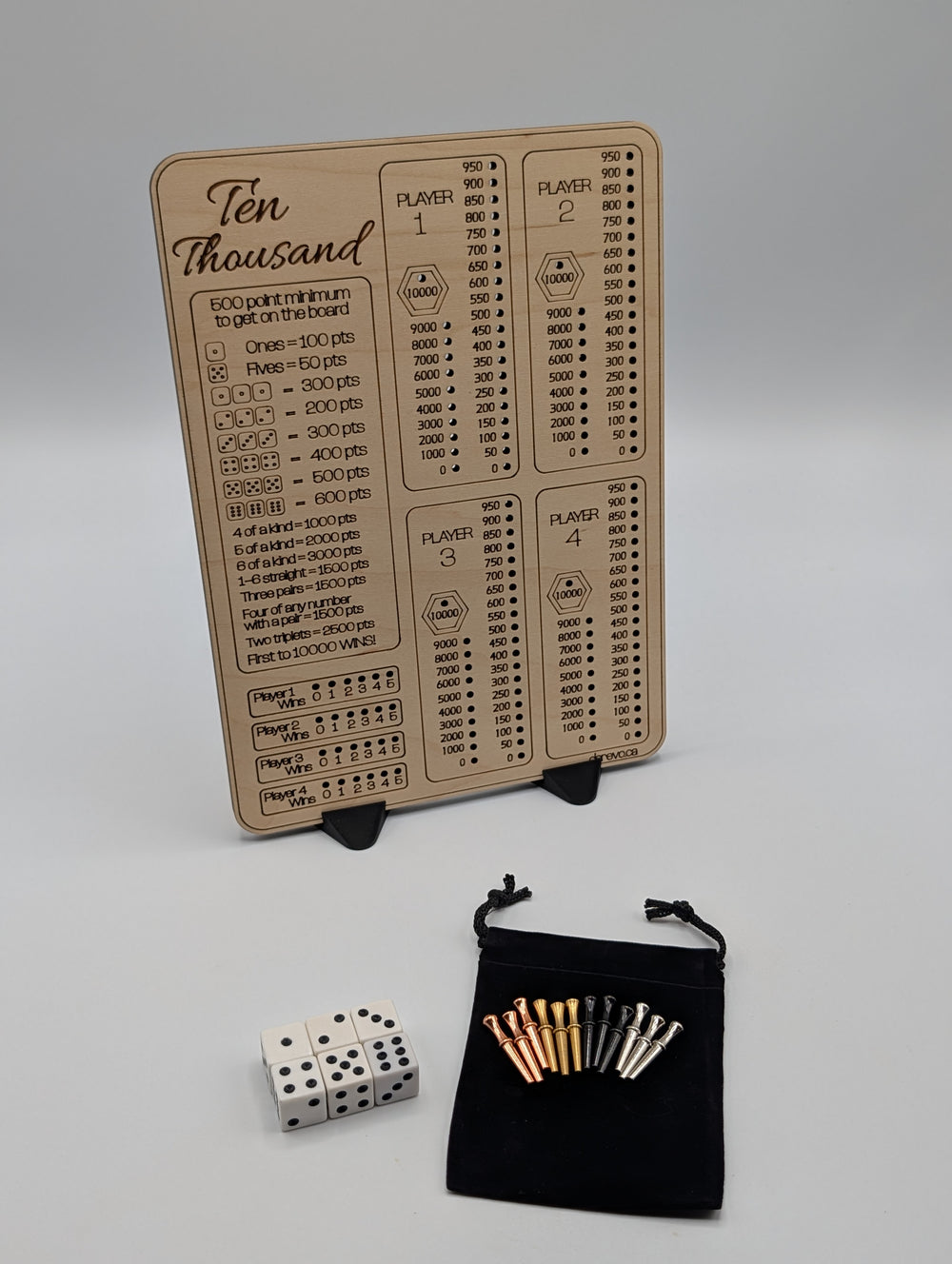Ten Thousand maple score board with four player tracks and an engraved scoring guide, shown with dice, metal pegs, pouch and two stands.
